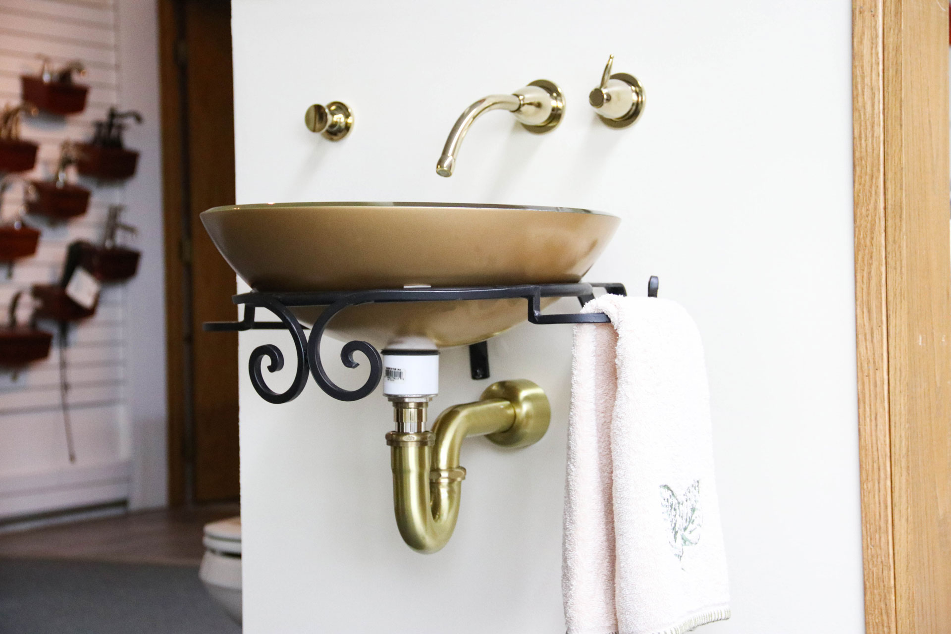 Gold vessel sink with brass fixtures.